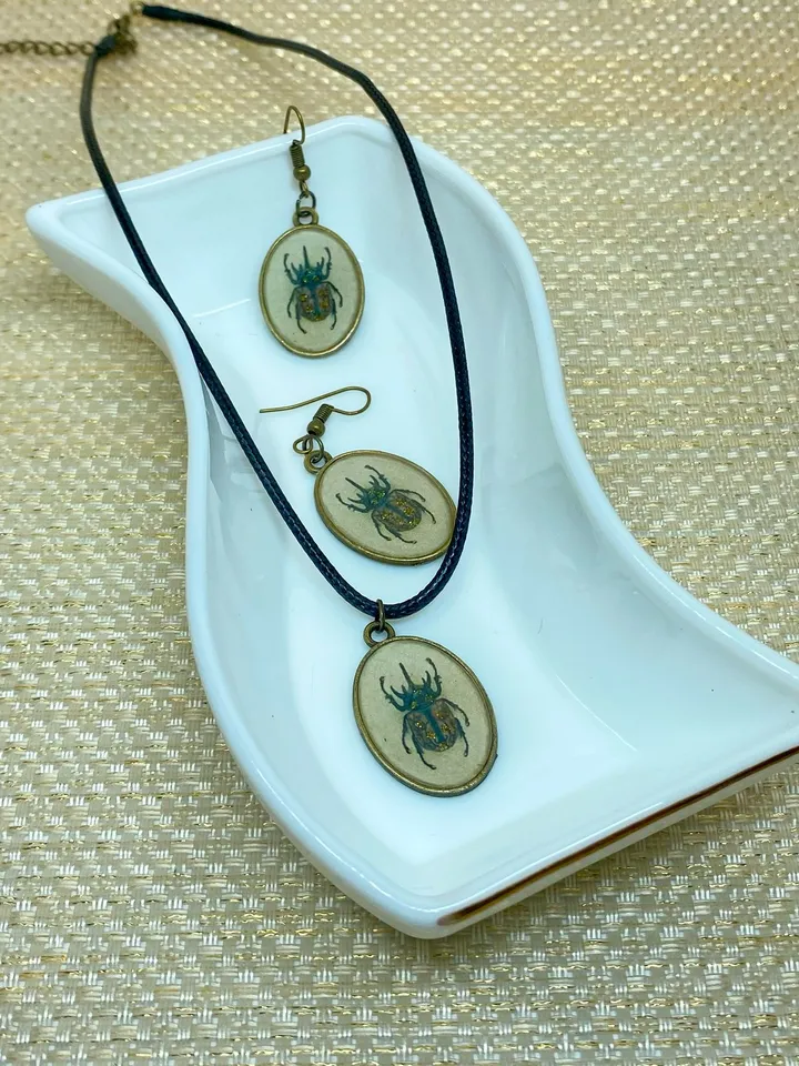 A set of jewelry with the image of beetles. Individual design.