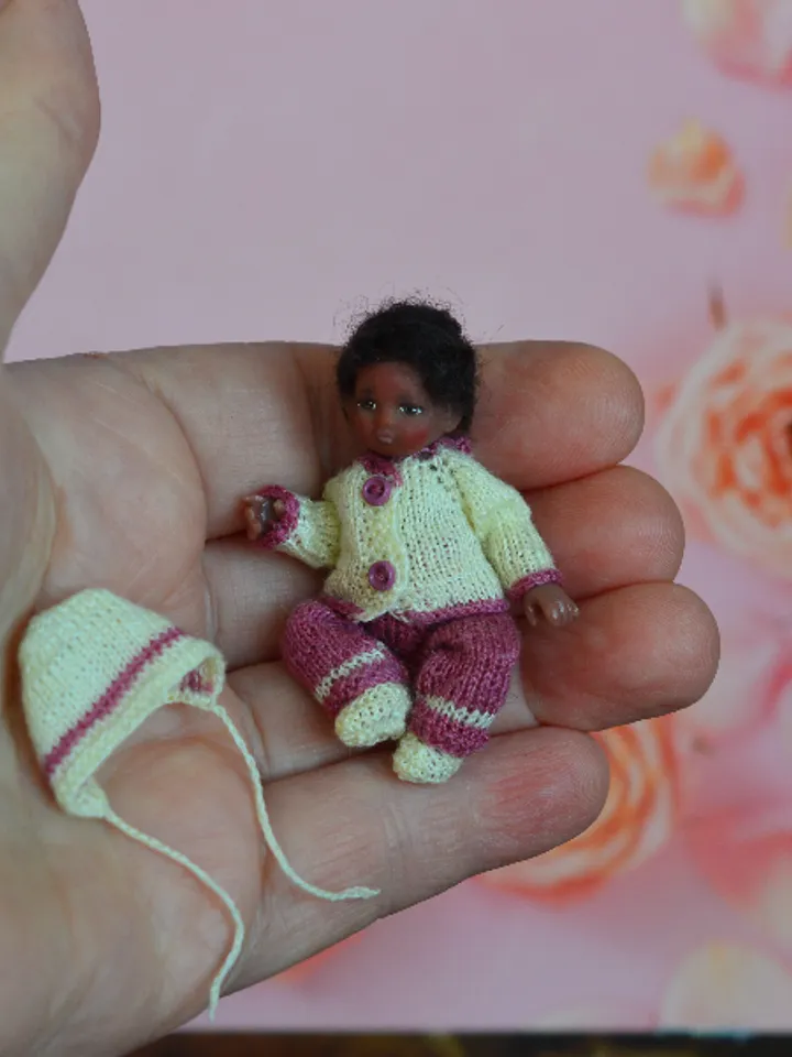 Miniature doll child in 12th scales. A baby for the dollhouse. Baby in a knitted suit.