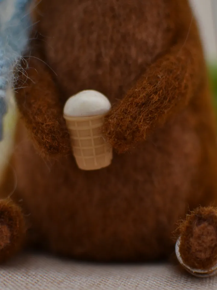 Handmade toy. Dachshund puppy in a scarf, with ice cream and a ball