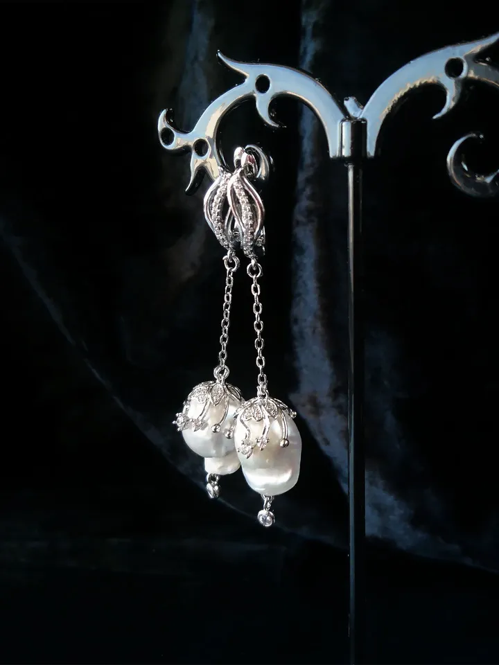 Earrings with baroque pearls and circus pendants on chains