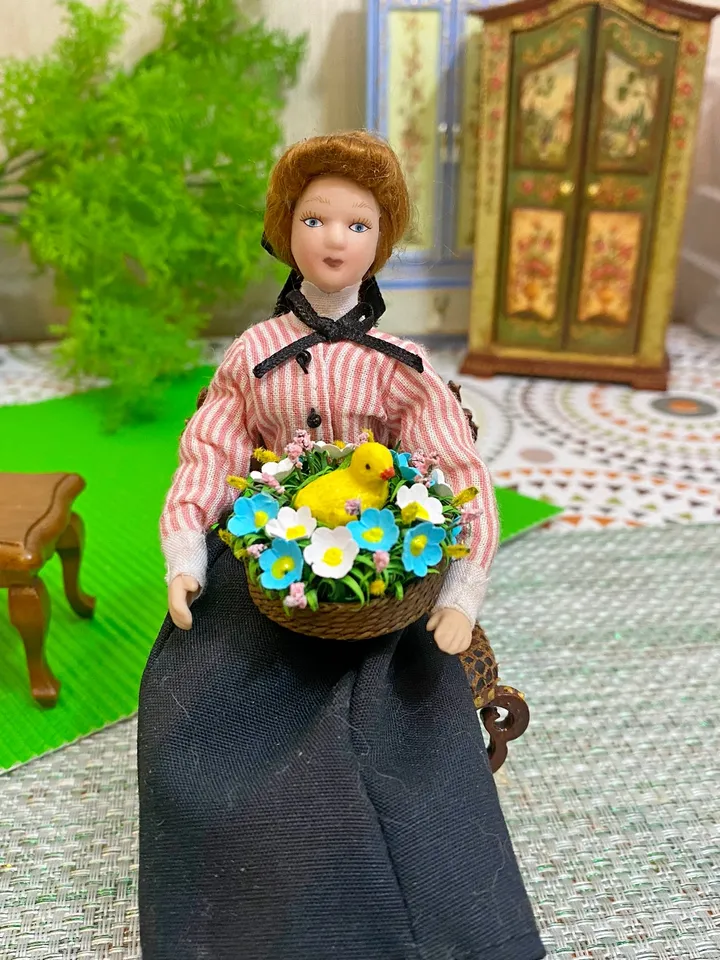 Easter miniature.Chicken in a basket with flowers.