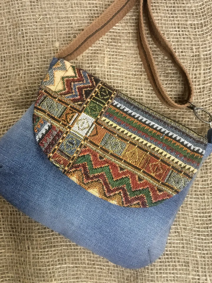A small crossbody bag, a women's messenger bag with a tapestry flap, a denim shoulder bag with pockets inside and an adjustable strap