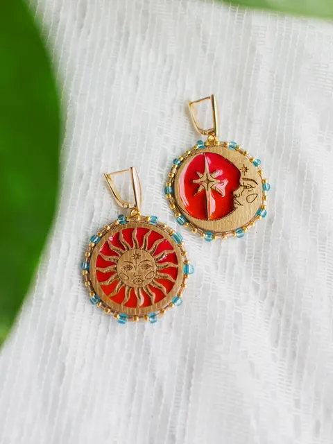 Asymmetrical statement earrings When The Sun Meets The Moon.  Gold jewelry with celestial design in sunset red and orange color with beading. Maylina Soul
