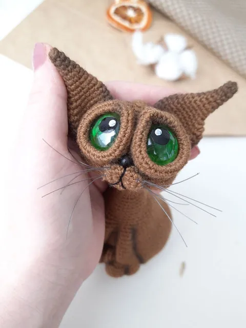 Crochet sculpture of a graceful brown cat with green eyes. Big-eyed cat as a gift for cat lovers.