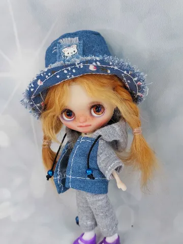 A little Blythe doll with red hair and brown eyes. a girl in a denim outfit. $240.00